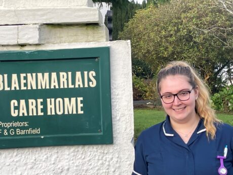 Elen Lewis standing outside the care home in her uniform.