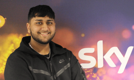 Sean standing in front of Sky logo