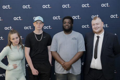 ACT JGW+ learners standing infront of a backdrop board.
