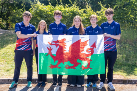 The competitors standing together holding the Welsh flag.