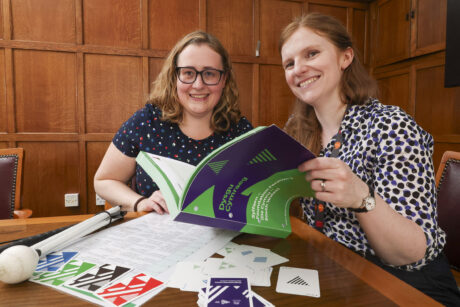 Hannah and her tutor looking at a book together.